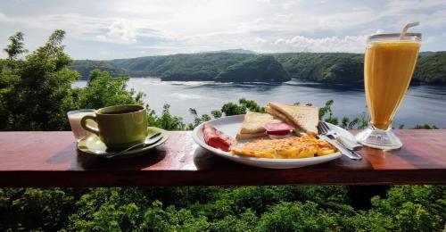 a plate of breakfast food and a cup of orange juice at Butterfly Villas Nusa Ceningan in Nusa Lembongan