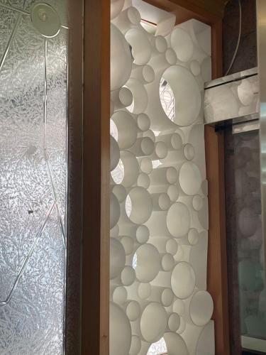 a wall of white plates on a wall next to a door at Wenpin Hotel - Pier 2 in Kaohsiung