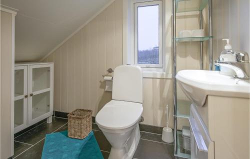 a bathroom with a toilet and a sink and a window at Beautiful Home In Stokmarknes With House A Panoramic View in Stokmarknes