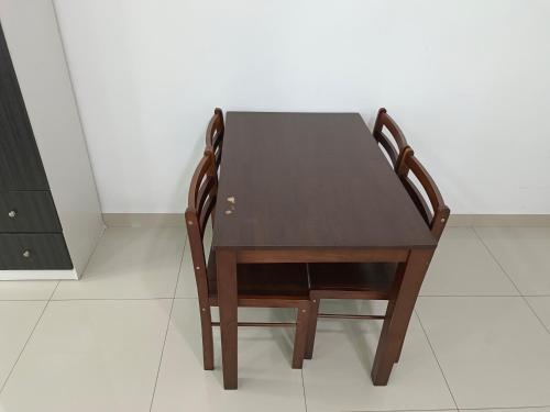 a wooden table and two chairs sitting on a floor at Peace home cybersqure 2 in Cyberjaya