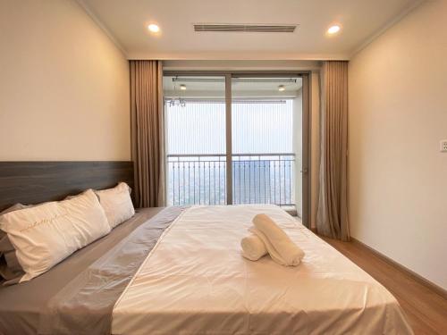 a bedroom with a large bed with two towels on it at Vinhomes Gardenia 16 Hàm Nghi,Mỹ Đình,Nam Từ Liêm in Hanoi