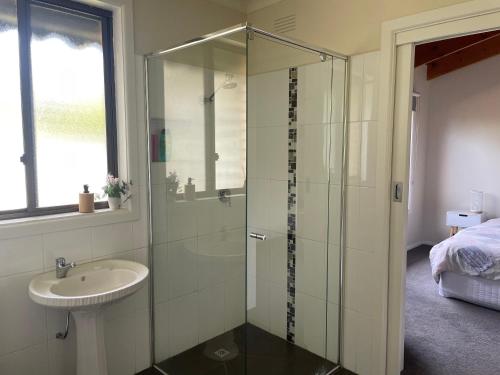 a bathroom with a glass shower and a sink at Close to Coast & Bellarine Peninsula in Moolap