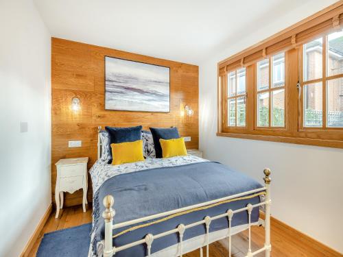 1 dormitorio con 1 cama con almohadas azules y amarillas en Copse Lodge en Eling