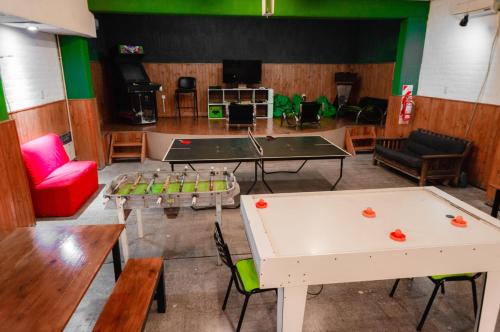 una sala de ping pong con mesas de ping pong y una mesa de ping pong en Clover Hostel en Mendoza