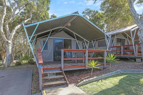 a tent with a staircase in front of it at Reflections Bonny Hills - Holiday Park in Lake Cathie