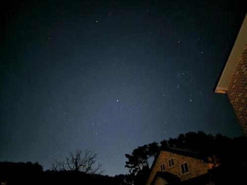 a starry night with a building in the foreground at Gyeongpodae Darakbang in Gangneung