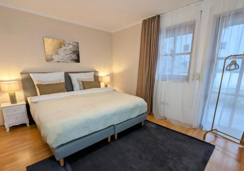 a bedroom with a large bed and a large window at FeWo Goldstück mit privatem SPA und Whirlpool in Grafenau