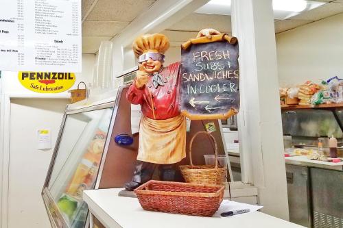 a statue of a chef standing next to a sign at Sandaway Suites & Beach in Oxford