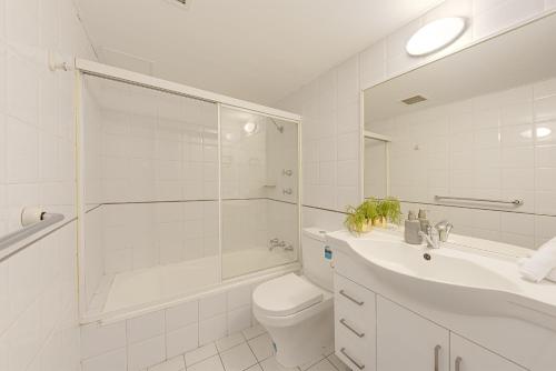 a bathroom with a toilet and a shower and a sink at Spacious & Cosy 2 Bedroom Apartment in Darling Harbour in Sydney