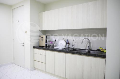 a kitchen with white cabinets and a sink at Lovely 3-bedrooms with Karaoke Genting Penthouse in Genting Highlands