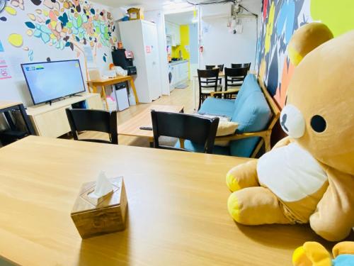 a large teddy bear sitting on top of a table at Aroha Guesthouse Seoul Station in Seoul