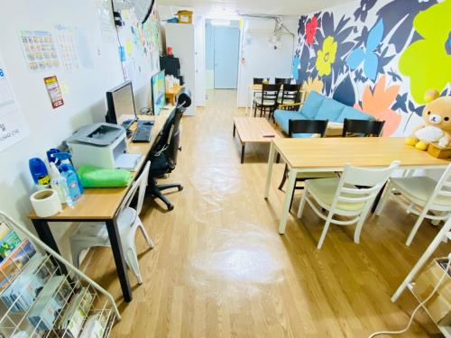 a classroom with desks and tables with a bear on the wall at Aroha Guesthouse Seoul Station in Seoul