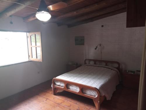 1 dormitorio con 1 cama en una habitación con ventana en Los colibries en Salsipuedes