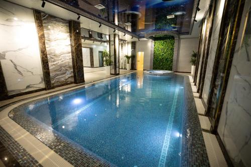 a large swimming pool in a building with a tile floor at Continental Hotel Samarkand in Samarkand
