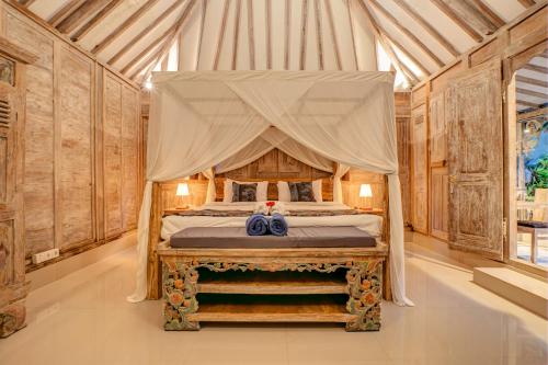 a bedroom with a canopy bed in a tent at Pratiwi Ubud Villa in Ubud