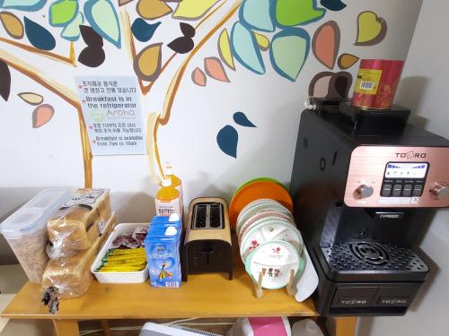 a shelf with food and a coffee maker on it at Aroha Guesthouse Seoul Station in Seoul