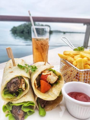 a plate with two sandwiches and french fries and a drink at Novotel Suva Lami Bay in Suva