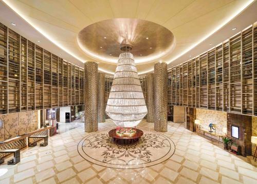 a lobby with a large vase in the middle of a building at Sanding New Century Grand Hotel Yiwu in Yiwu