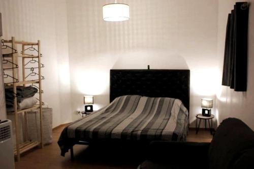 sypialnia z łóżkiem z paskowym kocem i 2 lampami w obiekcie Au cœur de Saint Chamas w mieście Saint-Chamas