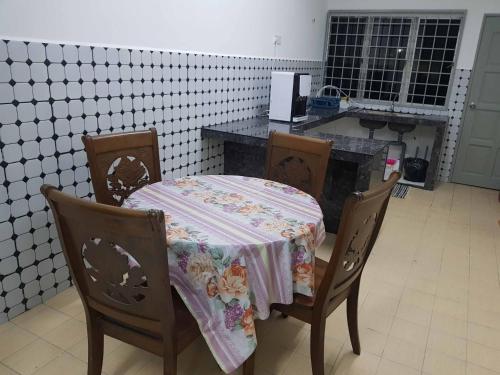 une table avec un chiffon de table dans une cuisine dans l'établissement 4 Bedroom House Indera Mahkota 8 Kuantan Homestay, à Kuantan