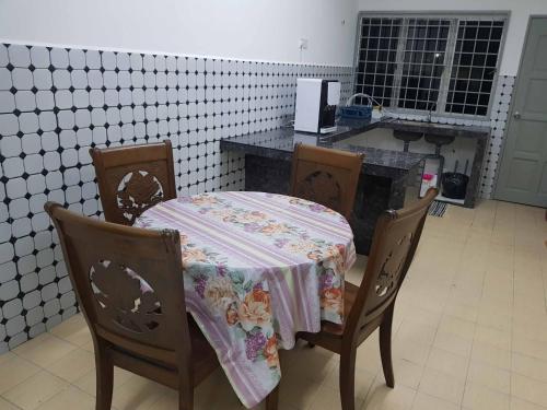 a table with a table cloth on it in a kitchen at 4 Bedroom House Indera Mahkota 8 Kuantan Homestay in Kuantan