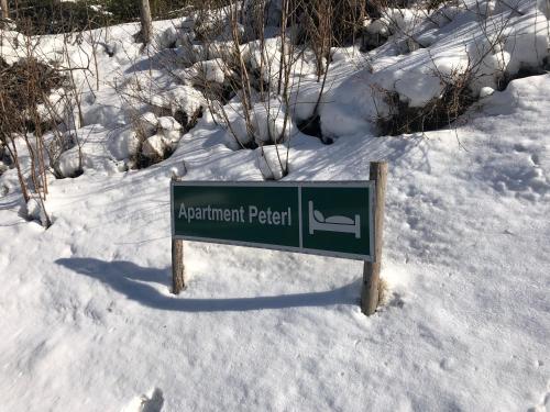 a sign in the snow next to a snow covered field at Apartment Peterl in Alpl