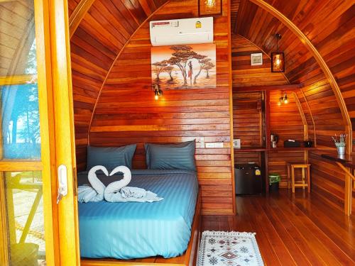 a bed in a room with two swans on it at Mumsa Beach Resort & Restaurant in Ban Huai Yang