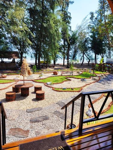 a park with a bench and tables and trees at Mumsa Beach Resort & Restaurant in Ban Huai Yang