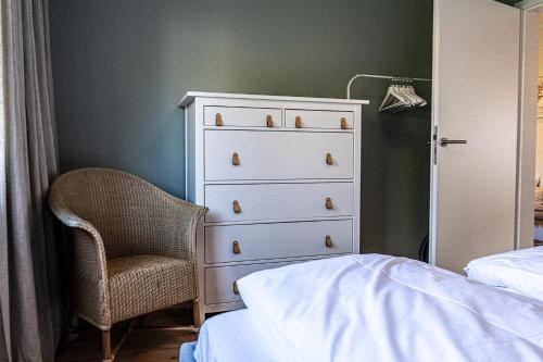 een slaapkamer met een dressoir en een stoel naast een bed bij Fräulein Emelie in Oberstaufen
