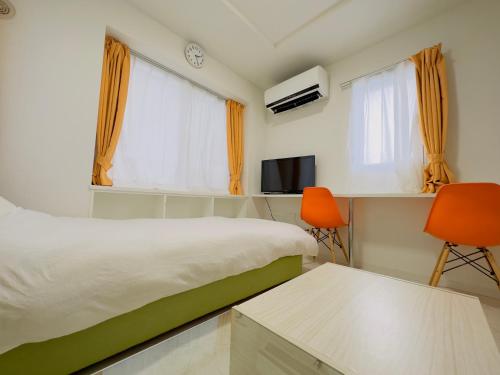 a bedroom with a bed and two orange chairs at 3-1 New Open地下鉄徒歩4分　美室【サービスアパートメントSapporo大通東3】3-1 in Sapporo