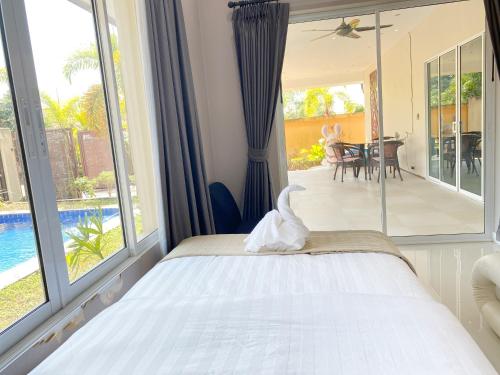 a bedroom with a bed with a view of the pool at Sunny4 villa Pattaya in Ban Huai Yai