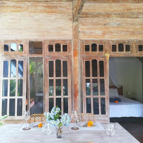 Una habitación con una mesa con flores. en The Joglo Kedungu, Traditional Teakwood en Tanah Lot