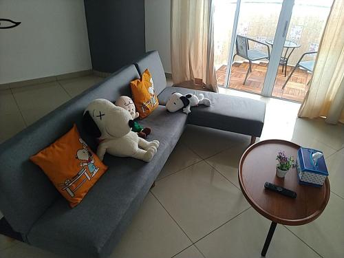a gray couch with stuffed animals on it at CloudView Snoopy Theme, Amber Court, Genting Highlands, 1km from Centre, Free Wi-Fi in Genting Highlands