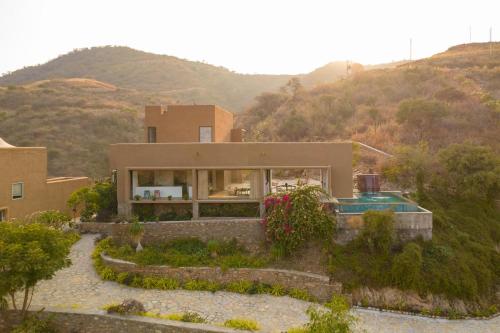 a house with a view of a mountain at StayVista's Sage Scenery - Mountain-View Villa with Infinity Pool & Terrace in Udaipur