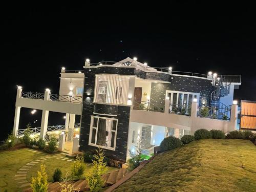 a large house with lights on top of it at Orchard Valley View in Ooty