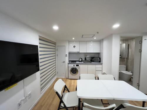 a kitchen and dining room with a white table and chairs at 318 Stay in Seoul