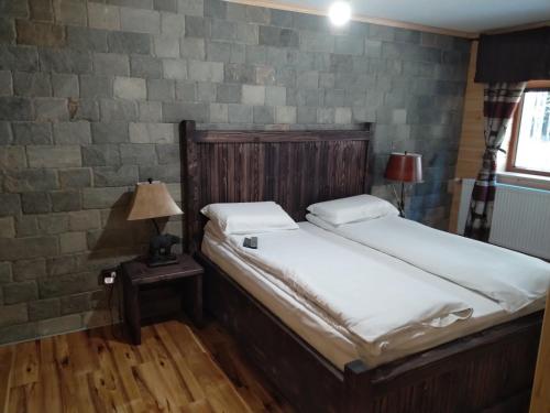 two twin beds in a room with a brick wall at Algara hut in Panichishte