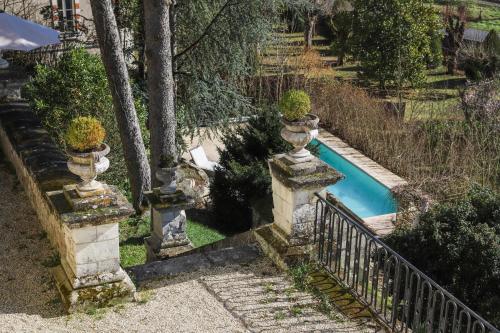 - une piscine dans une cour avec 2 urnes dans l'établissement Manoir de la Salle du Roc, à Bourré