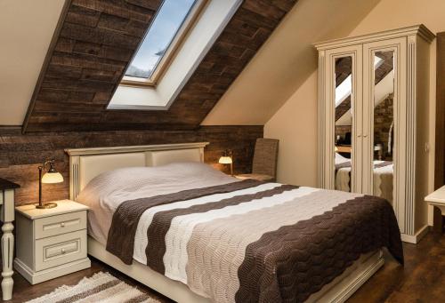 a bedroom with a bed and a skylight at Poiana Golf Chalet in Buşteni