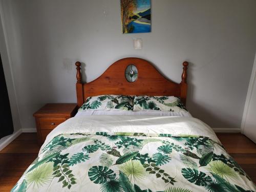 a bed with a green and white comforter at Homestay near Dandenong Plaza in Dandenong