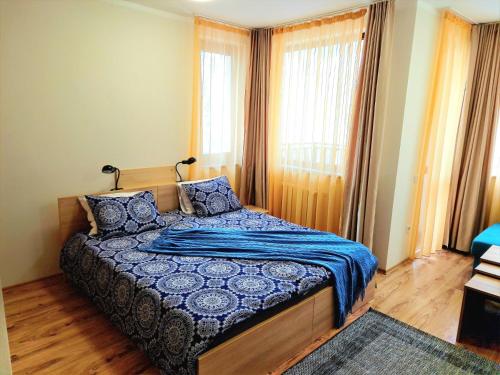 - une chambre avec un lit et une couette bleue dans l'établissement Студио D-41 в Апарт-хотел Боровец Гардънс, à Borovets