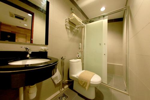 e bagno con servizi igienici, lavandino e doccia. di Ming Paragon Hotel a Kuala Terengganu