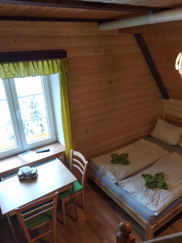 a room with a bed and a table in a cabin at Apartmány Černá Říčka in Desná
