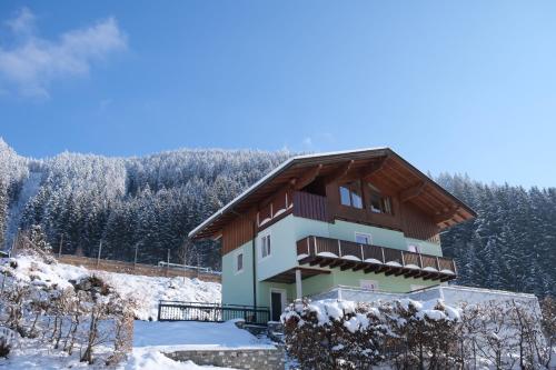 a building in the snow with snow covered trees at GO FOR MOUNTAINS Appartements in Eben im Pongau