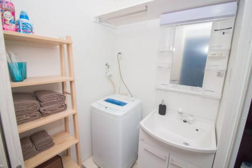 ein Badezimmer mit einem Waschbecken, einem WC und einem Spiegel in der Unterkunft D2HOTEL in Osaka