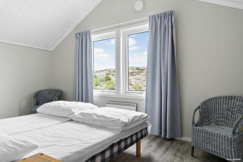 - un lit et deux chaises dans une chambre avec fenêtre dans l'établissement First Camp Solvik-Kungshamn, à Väjern