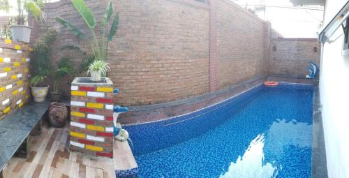 a swimming pool in a building with a brick wall at Hue Four Seasons Hotel in Hue