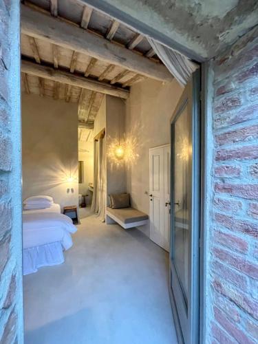 a bedroom with two beds and a brick wall at La Saracina in Pienza
