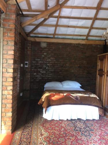 a brick room with a bed in a brick wall at African feel studio with kitchenette - 2045 in Harare