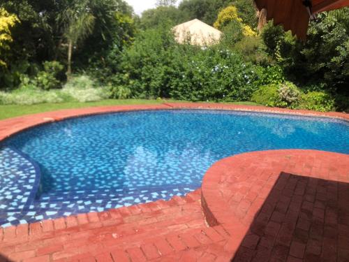 a large blue swimming pool in a yard at African feel studio with kitchenette - 2045 in Harare